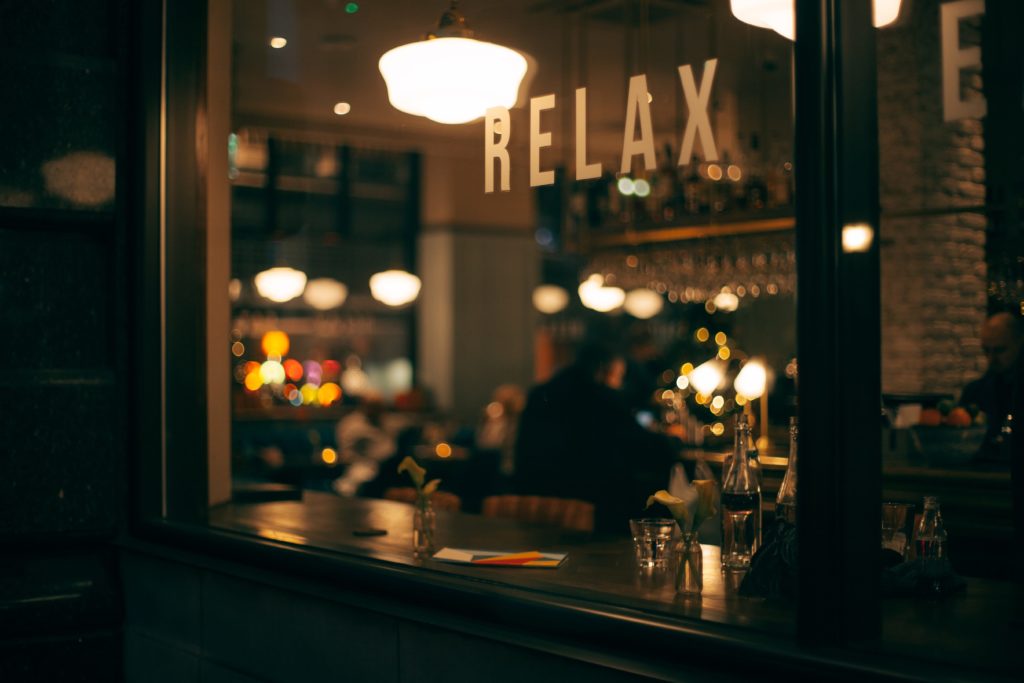Napis "relax" na szybie kawiarni.